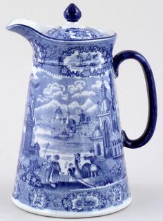 a blue and white coffee pot with a painting on it