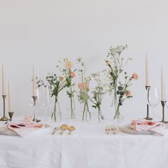 the table is set with flowers and candles