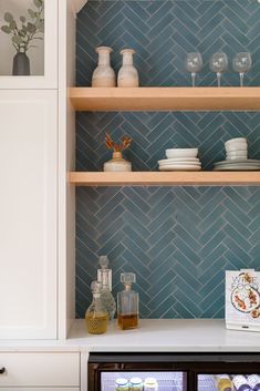 the shelves in this kitchen are filled with dishes and glasses