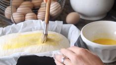 a person using a spatula to spread eggs on top of some bread and other ingredients