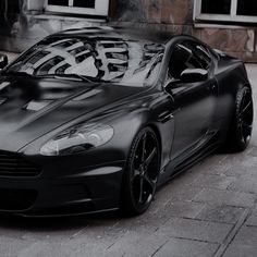 a grey sports car parked in front of a building