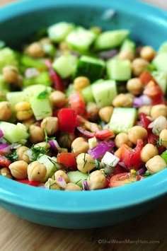 a blue bowl filled with cucumber, red onion and chickpea salad