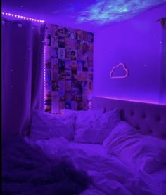 a bed in a room with purple lights on the wall and pictures hanging above it