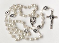 Handmade rosary beads. Made with silver metal wire and 6mm glass faux pearls,silver tonemiraculous medals on the place of Our father beads,miraculous medal centrepiece and st benedict crucifix. Give a gift of love and prayer with these wonderful rosaries. Hand made in Medjugorje. Feel free to contact me if you have any question. Thank you for stopping by! For more similar items and different colors visit our store: https://www.etsy.com/shop/Thelightjewelry?ref=seller-platform-mcnav Elegant White Cross Rosary, Elegant Silver Rosary For First Communion, Silver Pearl Rosary With 8mm Beads, White Crucifix Rosary With Miraculous Medal, Pearl White Rosary For First Communion, Silver Pearl Rosary For First Communion, Wedding Silver Pearl Rosary, White Rosary, St Benedict Bracelet