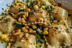 a white plate topped with ravioli and corn on top of broccoli florets