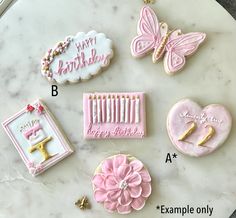 decorated cookies on top of a marble table with the words happy birthday written in gold