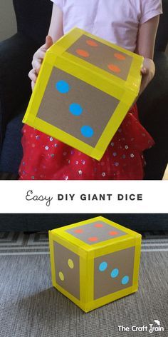 a child is holding up a giant box made out of cardboard and the words easy diy giant dice on it