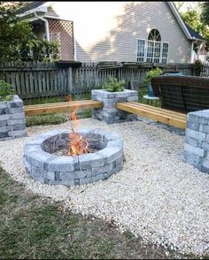 an outdoor fire pit with benches around it