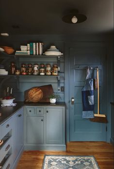 a kitchen with blue cabinets and wooden flooring is pictured in this image from the front door