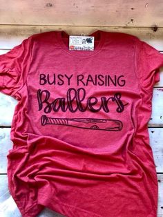 Baseball Mom Shirt, Baseball Shirt, Busy Raising Baller, Baseball Tee, Baseball Mom, Biggest Fan, Sh Mom Shirt Ideas, Shirt Ideas Vinyl, Baseball Videos, Raising Ballers, Baseball Mom Shirt, Confidence Kids, Team Mom, Baseball Tees