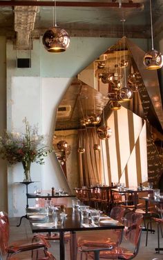 a large mirror in the middle of a dining room with chairs and tables around it