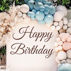 a happy birthday sign surrounded by balloons and flowers