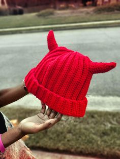 a person wearing a red knitted devil hat