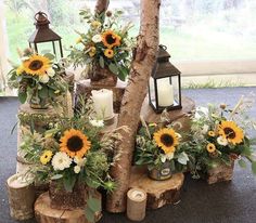 sunflowers and other flowers are arranged on logs