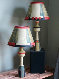 two lamps sitting on top of a wooden shelf