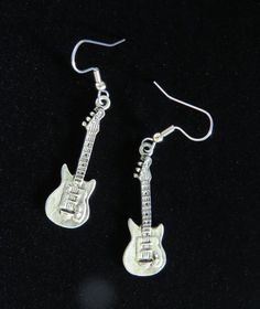 "Electric Guitar Earrings Oxidized Matte Silver. They measure approx. 1/2\" by 1-1/2\". I only use Surgical Steel Ear Posts or Wires for all my Earrings. More can wear these over all others. Great for Sensitive ears. I also make other Music theme Jewelry. (Flash washed them out a little, they are darker and show more detail). Please see my Etsy Shop for more Unique Handcrafted Jewelry. Please email me with any questions. As Always from a smoke free home.     Free Shipping in the U.S.     Combine Nickel-free Music-themed Jewelry For Concerts, Silver Rocker Style Jewelry For Concerts, Silver Rocker Style Jewelry For Gift, Guitar Earrings, Unique Handcrafted Jewelry, Rock Jewelry, Hannah Montana, Funky Jewelry, Star Gift