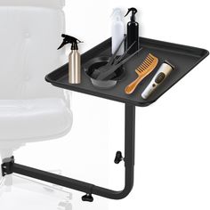 a black tray with hair products on it next to a white chair