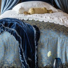 a bed with blue sheets and pillows on top of it