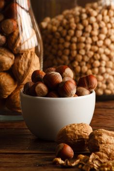 a bowl full of nuts sitting on top of a wooden table