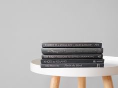 a stack of books sitting on top of a white table