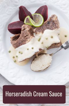 horseradish cream sauce on a plate with sliced beets and lime wedges