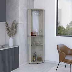 an empty room with a chair, cabinet and vase on the floor in front of a window