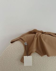 the back of a couch with a price tag on it's arm and an empty piece of paper attached to the pillow