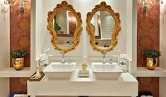 a bathroom with two sinks and mirrors on the wall