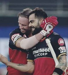 two men in red and black uniforms hugging each other with their arms around one another