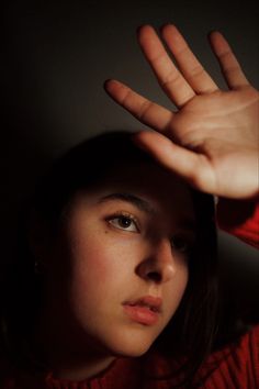 a woman holding her hand up to the camera