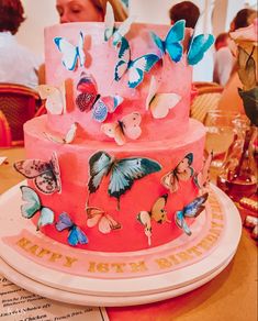 there is a pink cake with butterflies on it