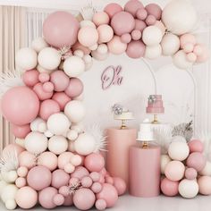 a pink and white dessert table with balloons