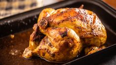 a cooked chicken sitting in a pan on top of a table