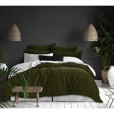 a bedroom with black walls and white flooring is pictured in this image, there are plants on either side of the bed