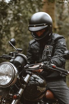 a man in black jacket and helmet sitting on motorcycle with headlight turned to the side