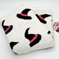 two white and black knitted items laying next to each other on a white surface