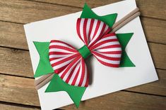 a red and white striped bow on top of a piece of paper