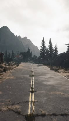 an empty road with trees and mountains in the background