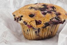 a blueberry muffin sitting on top of white paper