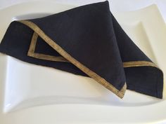 two black napkins sitting on top of a white plate