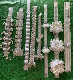 many different types of bracelets on display in front of a green cloth covered wall