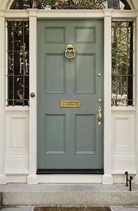 the front door is painted blue and has an arched glass window above it, along with two sidelights on either side