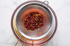 a metal strainer filled with food on top of a white counter