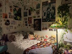 a bedroom with many pictures on the wall and stuffed animals on the bedspread