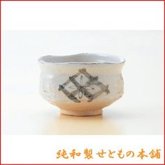 a small white bowl with black designs on the outside and red trimmings around it