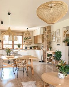 an open kitchen and dining room with wood flooring, wicker chandelier