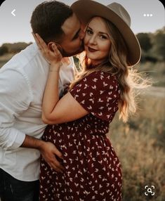 a man and woman kissing in a field