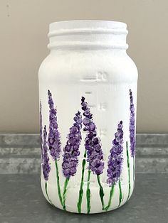 a painted mason jar with lavender flowers on it