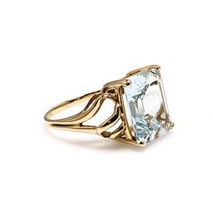 "Simple and elegant, this gorgeous pale blue 5.11-carat aquamarine is set into 14K yellow gold. The glistening gold pops against the sparkly aquamarine. Crafted in the 1990s, the emerald-cut gemstone delivers excellent light return, making the ring glow. A perfect gift for a March baby! The name aquamarine means \"seawater\" in Latin and is thought to contain the spirit of the ocean. Ancient sailors thought that wearing aquamarine would calm stormy seas. Aquamarine is a member of the beryl famil Aquamarine Meaning, Wedding Ring Finger, March Baby, Yellow Gold Solitaire Ring, Blue Gemstone Ring, Stormy Seas, Blue Gemstone Rings, Yellow Gold Solitaire, Gold Solitaire Ring