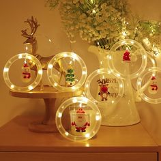 lighted glass plates with santa's and reindeers on them sitting on a table